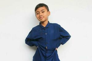 Smiling boy wearing blue shirt while looking at the camera isolated on white background photo