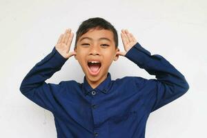 Cheerful little boy in express funny face, isolated on white background. A 10 years old boy making a funny face. photo