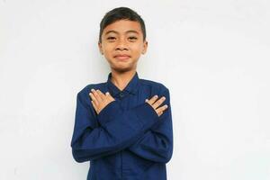 Smiling confidence boy looking at the camera while put his hand on chest, isolated on white background photo