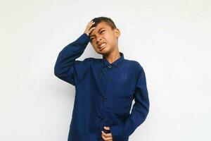 Beautiful kid boy wearing casual shirt standing over isolated white background suffering from strong headache, desperate and stressed because of overwork. Depression and pain concept. photo