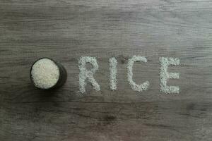 Rice, rice grains form RICE lettering on the wooden background photo