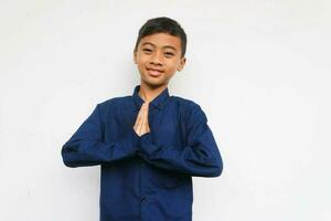 Smiling confidence boy looking at the camera with greeting hand, isolated on white background photo