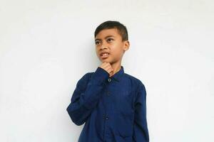 Boy wearing blue shirt smiling amazed looking at something, isolated on white background photo