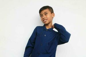 Cute bewildered boy in blue shirt looking at camera with smile isolated on the white background photo