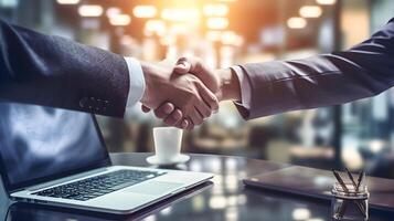 cooperation, recruitment between two people shaking hands with laptops at the table photo