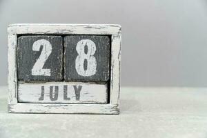Calendar for July 28, made of wooden cubes, on gray background.With an empty space for your text.Hepatitis Day. photo
