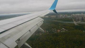 aereo discendente al di sopra di il città, Visualizza a partire dal il oblò. aereo ala e nuvole. lembi, Visualizza a partire dal il oblò. video