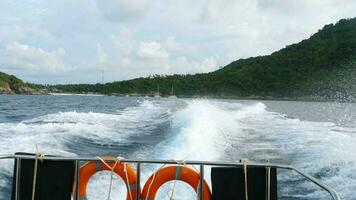 Waves on sea, splash, spray from speedboat. Scenic view of sea waves splashing against blue sky. Tourism and travel concept video