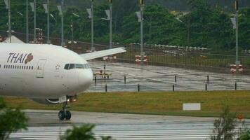 PHUKET, THAILAND DECEMBER 2, 2016 - Thai Airways Boeing 777 HS TKD taxiing before departure from Phuket International airport, rainy weather video