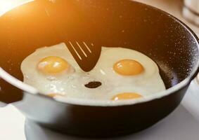 Person preparing fried eggs photo