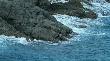 turkoois golven gerold Aan de rotsen, promthep kaap Bij zuiden van phuket eiland, langzaam beweging video