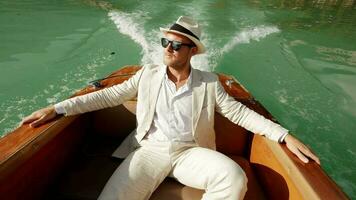 Happiness lifestyle portrait of young man in vintage style enjoying boat ride relaxing on lake video