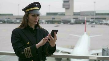 kvinna flygbolag kapten pilot officer i kostym arbetssätt på flygplats terminal video