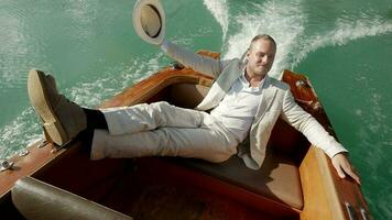 Happiness lifestyle portrait of young man in vintage style enjoying boat ride relaxing on lake video