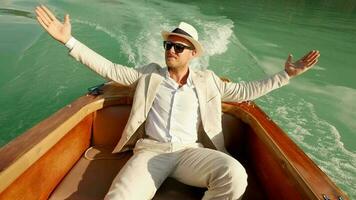 Happiness lifestyle portrait of young man in vintage style enjoying boat ride relaxing on lake video