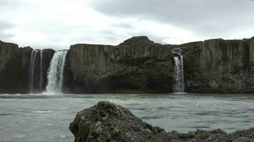 fantastico cascata nel un islandese paesaggio con rocce. video
