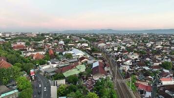 Aerial view of housing in Yogyakarta city at sunset with view of Mount Merapi in the distance, Indonesia. video