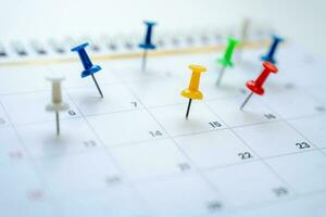 Red push pin in a calender on datebusiness meeting schedule, travel planning and reminder concept. photo