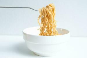 Eat instant noodles in a cup with a fork. photo