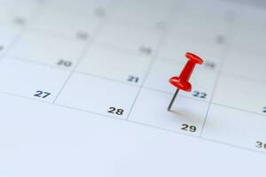 A red tack on the calenda. Planning for business meeting or travel planning concept. photo