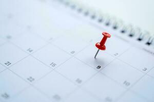 Calendar with red pins on the 9th, mark the date of the event with a pin. photo
