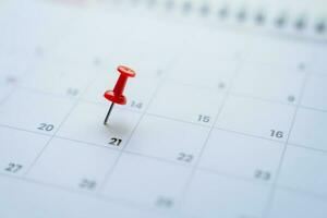 Close-up view of red pins with calendar for meeting reminders and appointments. photo