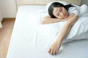 Young beautiful woman sleeping or take a nap in bed. Healthy Young female sleep with bedtime at home. photo