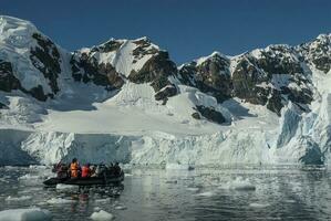 Tourists observing a glacier on the Antarctica, Paradise bay, Antartic Peninsula. photo