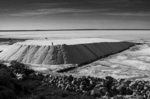 Trucks unloading raw salt bulk, Salinas Grandes de Hidalgo, La Pampa, Argentina. photo