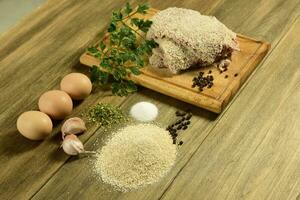 Veal milanese presented on the table with ingredients photo