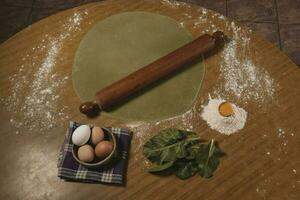 Egg dough for noodles, with ingredients on the table, traditional italian cuisine. photo