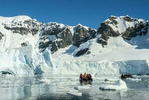 turistas observando un glaciar en el Antártida, paraíso bahía, antártico península. foto