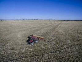 Tractor and seeder, direct sowing in the pampa, Argentina photo