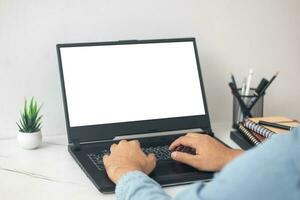 man's hands working on laptop at home desk photo