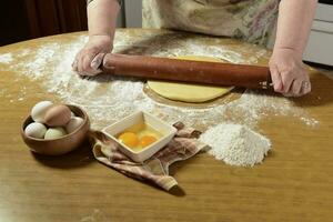 Egg dough for noodles, with ingredients on the table. photo