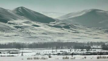 neigeux collines sur bord de plat grand plaine dans ensoleillé hiver video