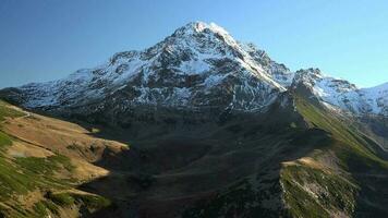 filmisch schneebedeckt hoch Berg Gipfel und Herbst bunt Senke video