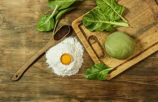 Green dough bun for noodles with ingredients on the table. photo