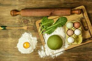 verde fideos masa bollo, con ingredientes en el mesa. foto