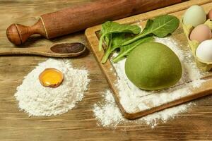 Green noodle dough bun, with ingredients on the table. photo