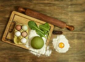 Green noodle dough bun, with ingredients on the table. photo