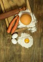 Orange carrot noodle dough bun, with ingredients on the table. photo