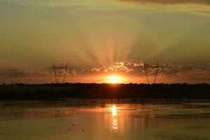 High voltage power line at sunset, Pampas, Argentina photo