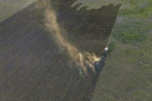 Tractor plowing the field, Pampas countryside, La Pampa, Argentina. photo