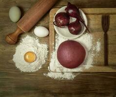 púrpura masa bollo para tallarines con ingredientes en el mesa. foto