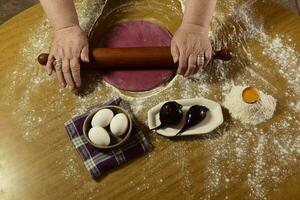 Grandma's hands kneading, dough for purple noodles. photo