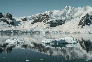 Snowy mountains in sunny day, Paraiso Bay, Antartica. photo