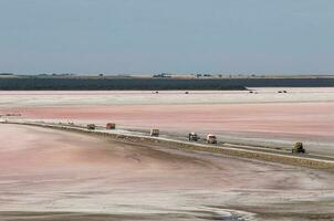 Trucks unloading raw salt bulk, Salinas Grandes de Hidalgo, La Pampa, Argentina. photo