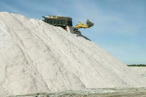 Trucks unloading raw salt bulk, Salinas Grandes de Hidalgo, La Pampa, Argentina. photo