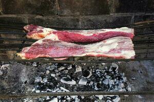 Raw meat put on the grill, traditional Argentine cuisine, Asado barbecue, Patagonia, Argentina. photo